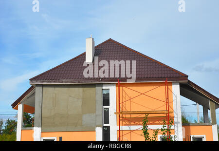 Bau oder Reparatur des ländlichen Haus mit Balkon, Traufe, Fenster, Schornstein, Metall, Ziegel Dach, Fassade, Wärmedämmung, Putz und Paintin Stockfoto