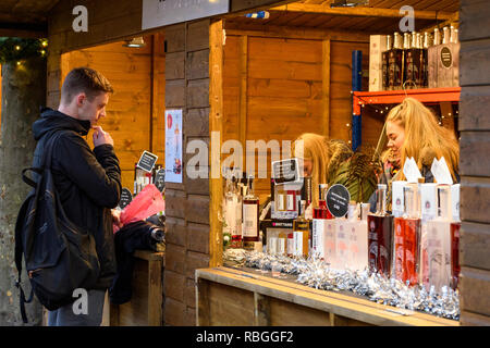 Menschen bei Abschaltdruck arbeiten verkaufen brittain Gin's & Wodka & potenzielle Kunden an Weihnachtsmarkt auf der Preisliste auf Anzeige - York, England, UK. Stockfoto