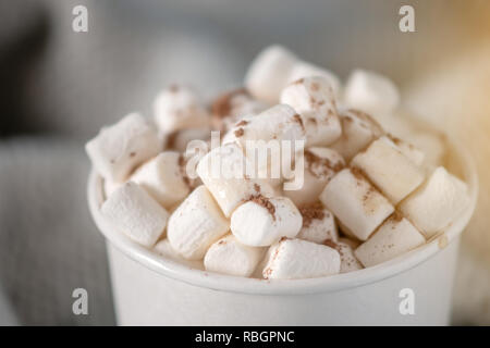 Weißbuch Tasse heiße Schokolade mit Marshmallows oben auf blauem Hintergrund. Gemütliche warme Winter Karte Stockfoto
