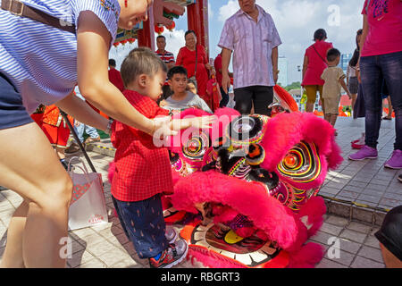 Kuala Lumpur, Malaysia - 16. Februar 2018: Junge berühren lion's head Kostüm während des chinesischen neuen Jahres Feier in Thean Hou Tempel. Stockfoto