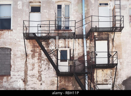 Heruntergekommene Gebäude mit Feuerleitern und viele Türen, interessante Wand Stockfoto