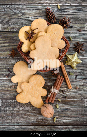 Ingwer Cookies auf einen Holztisch mit Gewürzen. Lebkuchen Männer. Das Symbol für Weihnachten. Vertikale Ansicht. Flach Stockfoto