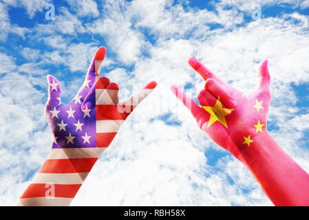 Usa und China Flagge Overlay auf zwei Hände zeigen stumme Sprache hand Liebe mit bewölktem Himmel Hintergrund, wirtschaftlichen Konzept Stockfoto