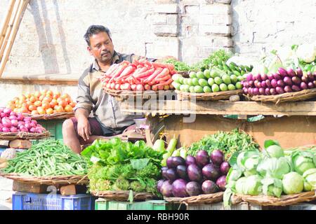 Indischer Gemüseverkäufer auf dem Lebensmittelmarkt in Varanasi, Indien. Kleine Gemüse- und Obsthändler werden in Straßengeschäften durch indische Städte und Städte verkauft Stockfoto