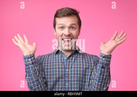 Wollen Sie mich veräppeln oder Oh mein Gott oder Wow-Konzept. Crazy schockiert junger Mann, an Kamera suchen mit weit geöffneten Mund und genervt die Augen, schreien auf Rosa ba Stockfoto