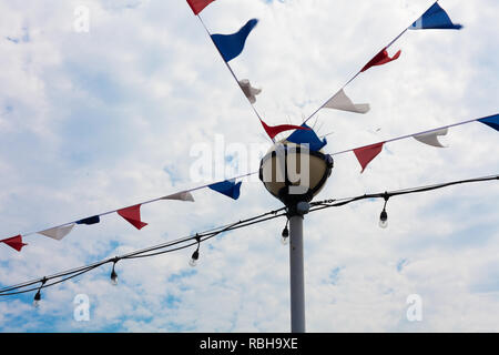 Festlichkeit Flagge und Saiteninstrumente Lampen hängen Horizontal von Lamp Post. Andere Farbe Banner für Attraktion. Dekoration Ideen bei der Feier eine Occas Stockfoto