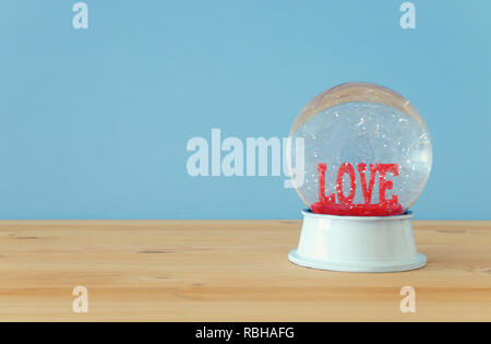 Valentinstag Hintergrund. Wasser Welt mit Wort LIEBE und Glitter auf den Holztisch und Blau bakground Stockfoto