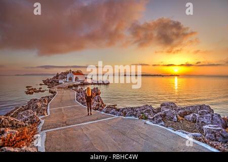 Eine Frau im Sunrise der kleinen Kirche Agios Isidoros in Insel Chios, Griechenland Stockfoto
