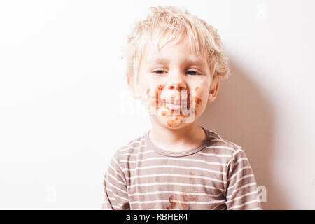 Junge eated Schokolade, lustige schmutzig lächelte Gesicht Stockfoto