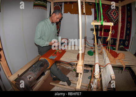 Hand webt einen wollenen Teppich auf dem Webstuhl zu einem Kunsthandwerksladen in Madaba Jordanien Stockfoto