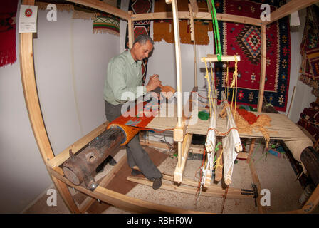 Hand webt einen wollenen Teppich auf dem Webstuhl zu einem Kunsthandwerksladen in Madaba Jordanien Stockfoto