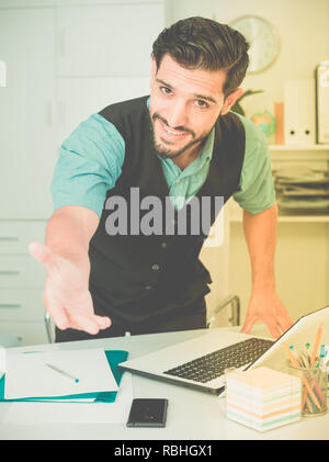 Spanischer mann Manager wird die ersten Besucher in seinem Büro zu treffen. Stockfoto