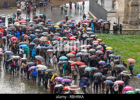 Rom, Italien, 07. Oktober 2018: Menschen mit Sonnenschirmen in der langen Schlange am Colosseum in Regen Stockfoto