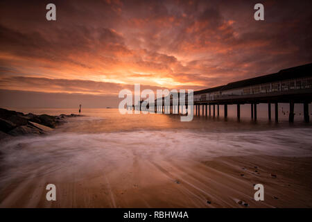 Sonnenaufgang am Strand von Southwold Pier in Suffolk, England Großbritannien Stockfoto