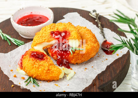Gebackenen oder frittierten Camembert oder Brie Käse mit Preiselbeeren und Rosmarin Sauce. Gourmet Frühstück. Selektiver Fokus Stockfoto