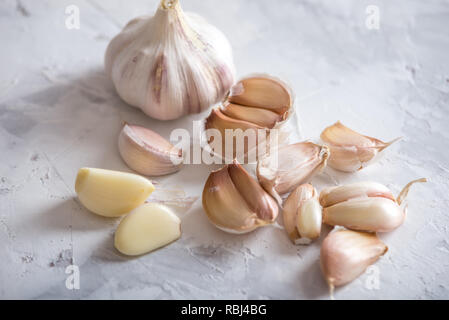 Gruppe der Knoblauchzehen auf eine Tabelle auf einem weißen Hintergrund. Ein wichtiger Bestandteil in verschiedenen Küchen der Welt. Ein gesundes Produkt. Stockfoto