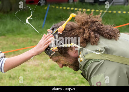 Joel Hicks als menschliches Ziel an der Welt Ei werfen Meisterschaften, Swaton Dorf Fair, Lincolnshire, Großbritannien Stockfoto