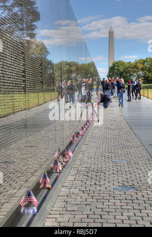 Menschen an der Mauer, das Washington Monument (Hintergrund), Vietnam Veterans Memorial, Washington D.C., USA Stockfoto