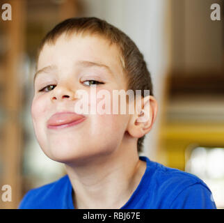 Ein Junge (6 Jahre alt) Gesichter ziehen an der Kamera Stockfoto