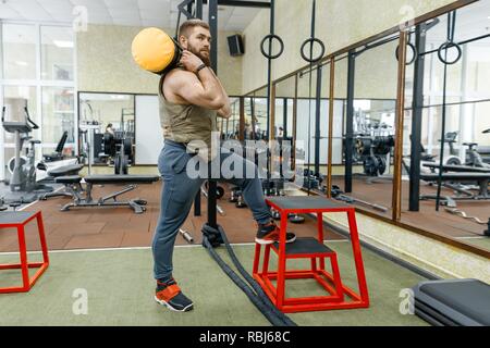 Wehrsport, muskulös kaukasischen bärtige erwachsene Mann Übungen in der Turnhalle in kugelsicher gepanzert Weste gekleidet. Stockfoto