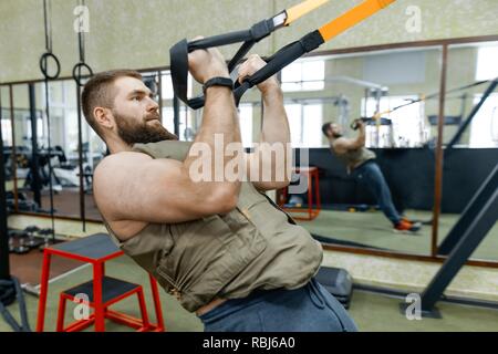 Wehrsport, muskulös kaukasischen bärtige erwachsene Mann Übungen in der Turnhalle in kugelsicher gepanzert Weste gekleidet. Stockfoto