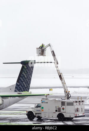 Ein Flughafen Mitarbeiter sprühen Heckscheibenheizung am Flügel eines Flugzeugs im Winter, das Flugzeug bereit für die Abreise. Die Stadt Quebec Jean Lesage Flughafen. Stockfoto