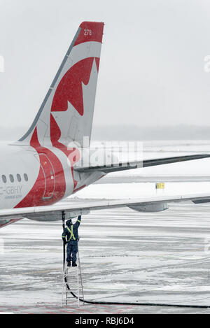 Ein Airbus A319 wird im Winter in der Stadt Quebec Jean Lesage Flughafen aufgetankt. Stockfoto