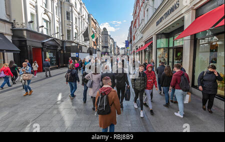 Menschen, Familien, Touristen zu Fuß und erkunden Sie die Grafton Street, einer belebten Geschäftsstraße in Dublin, Irland. Stockfoto