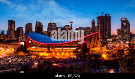 Panorama von Calgary Downtown Skyline bei Sonnenuntergang blaue Stunde mit der ikonischen Saddledome Arena und Calgary Tower im Hintergrund mit umgebenden Stadt Stockfoto