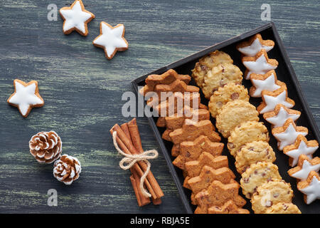 Weihnachten Chocolate Chip Cookies, flach mit Gewürzen und Winter Dekorationen auf dunklen rustikalen, mit Holz legen Stockfoto