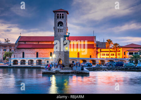 Rhodos, Griechenland. Atemberaubenden Sonnenuntergang bild Mandraki Hafen und Evaggelismos Kirche der Ort der Koloss von Rhodos. Stockfoto