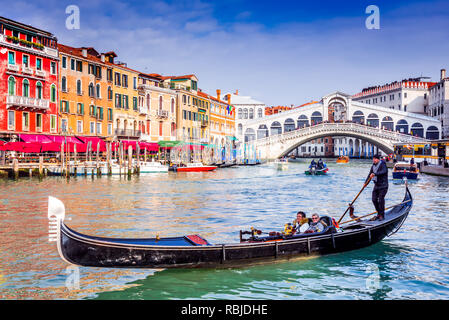 Venedig, Italien - Februar 2018: die Gondeln auf dem Canal Grande und der Ponte Rialto Waterfront, Sehenswürdigkeiten von Venedig. Stockfoto
