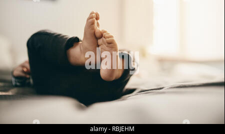 In der Nähe der Füße und Beine eines Kindes liegend auf dem Bett. Stockfoto