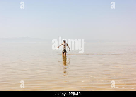 Ein Mann in flachen Gewässern von salt lake Urmia, West Provinz Aserbaidschan, Iran Stockfoto