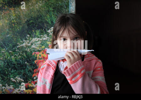 Portrait einer jungen ukrainischen Mädchen spielen mit einem Paper Plane während der Klasse Pausen in der Schule. Polesskiy Radinka, Bezirk, Kiev Oblast, Ukraine Stockfoto