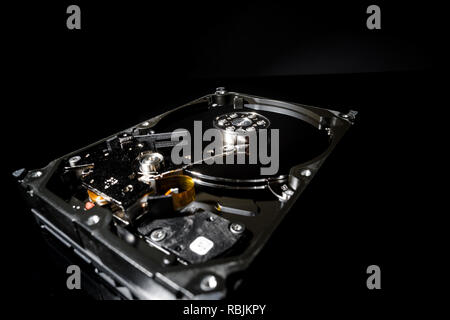 Zerlegt und Festplatte geöffnet, Innenansicht mit Reflexionen, isoliert auf Schwarz Stockfoto