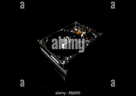 Zerlegt und Festplatte geöffnet, Innenansicht mit Reflexionen, isoliert auf Schwarz Stockfoto