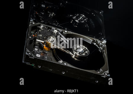 Zerlegt und Festplatte geöffnet, Innenansicht mit Reflexionen, isoliert auf Schwarz Stockfoto