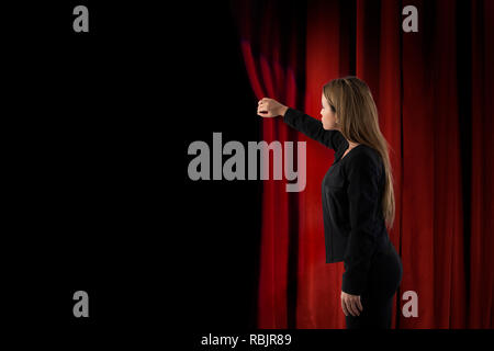 Frau öffnen rote Vorhänge der Bühne Stockfoto