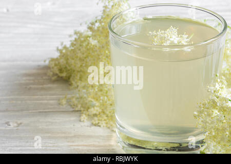 Hausgemachte Holunder Blume Sirup mit Blumen auf weißem Holztisch. gesunde pflanzliche trinken. Nach oben Schließen Stockfoto