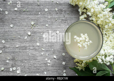 Holunderblüten Sirup mit Blumen auf weißem Holztisch. gesunde pflanzliche trinken. top View Stockfoto