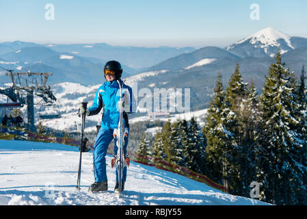 Volle Länge Schuß eines weiblichen Skifahrer im Winter Sportswear auf einem Berg mit ihren Skiern posing copyspace aktiven saisonalen Sport Lifestyle Freizeit Resort Konzept. Stockfoto