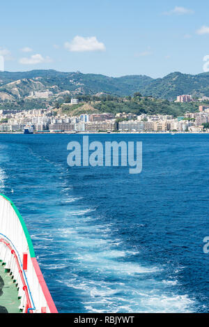 Blick auf das Meer vom Heck einer Autofähre über die Meerenge von Messina und im Hintergrund die Stadt Messina. Vertikale Ansicht Stockfoto