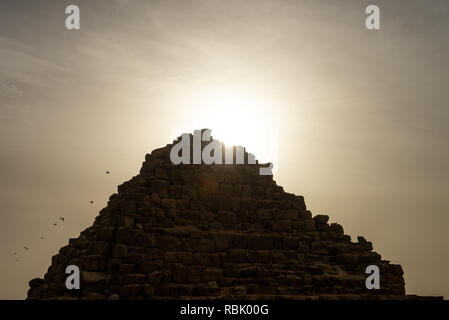 Das Grab der Königin Hetepheres in der Pyramide von Gizeh Komplex mit Sterne Strahlen der aufgehenden Sonne hinter sich und Tauben wegfliegen. Königin Hetepheres war ich ein Stockfoto
