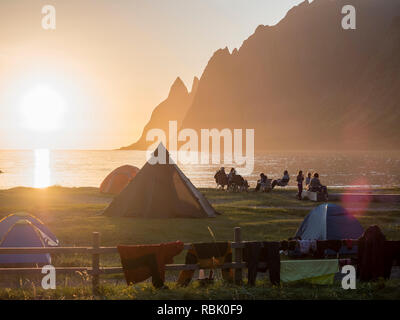 Strand Ersfjord Ersfjordstranden, Fjord, Menschen in kleinen Gruppen am Strand sitzen, öffentlichen Erholungsgebiet, Sonnenuntergang, Blick auf die Bergkette Okshornan Stockfoto