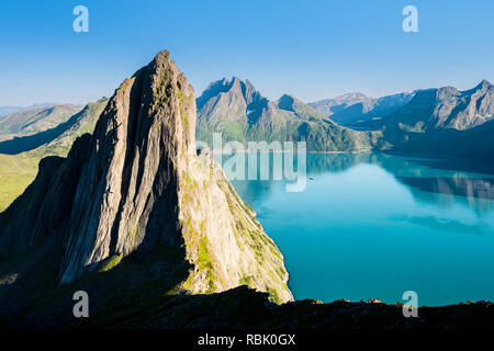Berg Segla vom Berg Hesten gesehen, Sommertag, Peak Breidtinden in der Rückseite, kleines Segelboot auf dem ruhigen Meer, Insel Senja, Troms, Norwegen Stockfoto