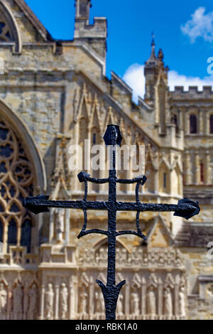 Dieses schmiedeeiserne Kreuz vor der Kathedrale von Exeter, der Kathedrale St. Peter in Exeter, ist eines von vielen Kunstwerken, die mit der Kathedrale in Verbindung stehen Stockfoto