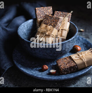 Rohe Schokolade Chia Samen bars mit Haselnüssen, Haferflocken, Termine, Kokosnuss und Honig Stockfoto