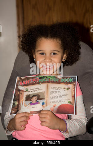 Vadnais Heights, Minnesota. Bi - rassische Kind ihren Namen auf Santa's schöne Liste angezeigt. Stockfoto