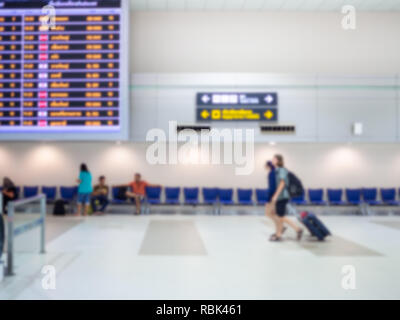 Verschwommen Boarding Time Bildschirme und Fahrgäste in Flughafen Halle terminal Innenbereich für Anreise Pkw. Stockfoto